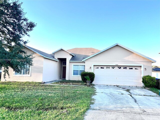 single story home with a garage and a front yard