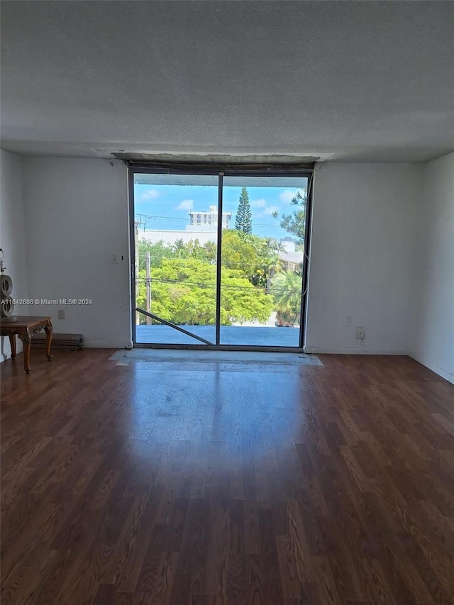 spare room with a textured ceiling and wood-type flooring