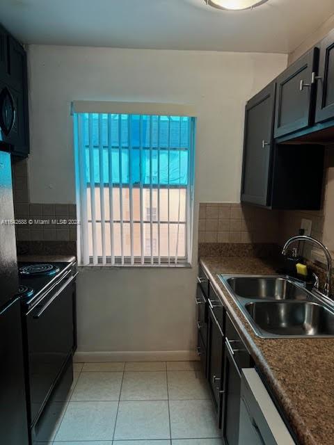 kitchen featuring light tile patterned floors, sink, tasteful backsplash, and black appliances