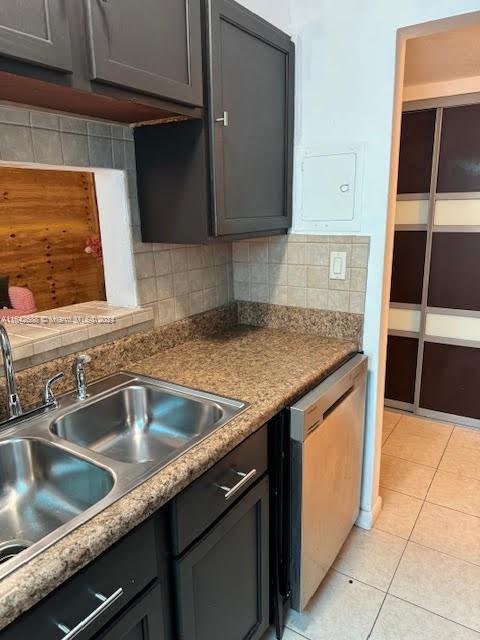 kitchen featuring sink, dishwasher, light tile patterned floors, and tasteful backsplash