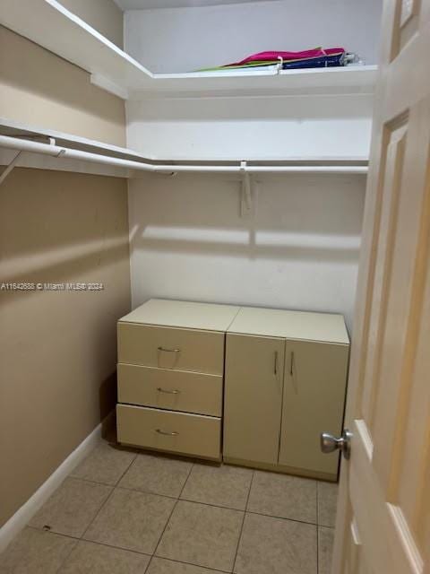 walk in closet featuring light tile patterned flooring