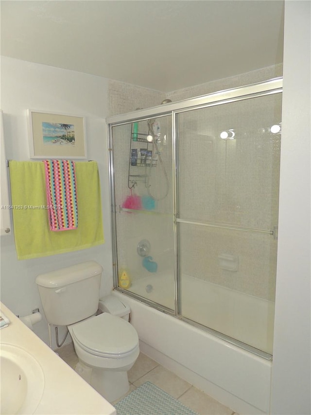 bathroom with tile patterned flooring, enclosed tub / shower combo, and toilet