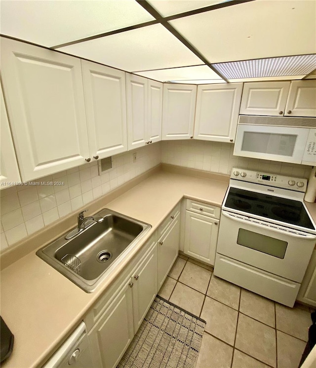 kitchen with light tile patterned flooring, sink, tasteful backsplash, and white appliances