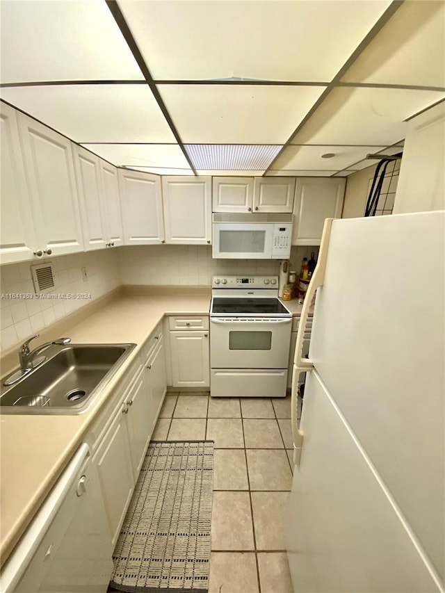 kitchen with light tile patterned flooring, sink, decorative backsplash, and white appliances