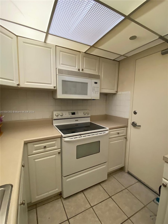 kitchen featuring tasteful backsplash, white cabinetry, white appliances, and light tile patterned floors