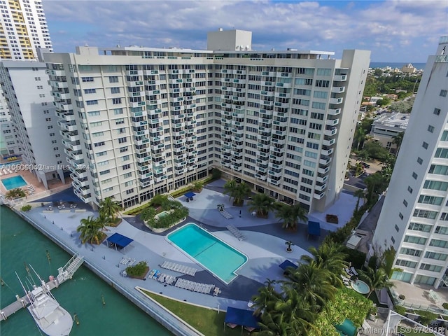 view of building exterior featuring a community pool and a water view