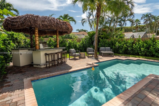 view of swimming pool with a patio and a bar