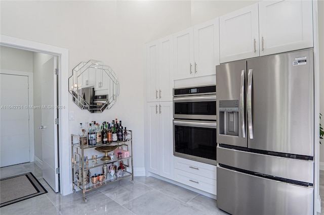 kitchen with stainless steel appliances, white cabinets, and light tile patterned floors