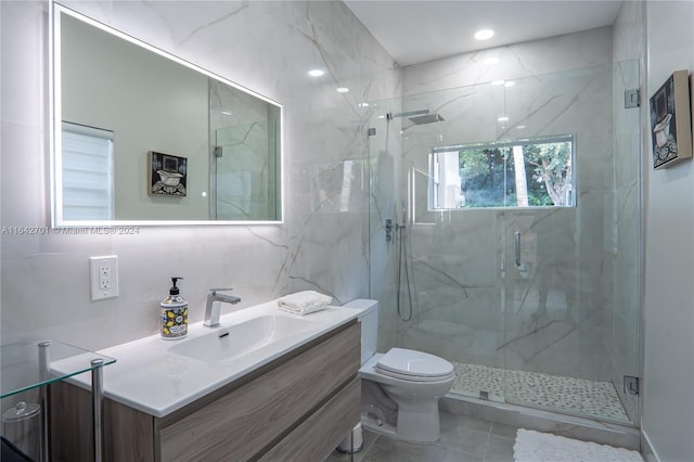 bathroom featuring tile patterned floors, a shower with shower door, vanity, tile walls, and toilet