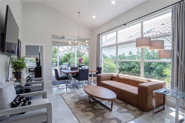 living room with high vaulted ceiling, plenty of natural light, and an inviting chandelier