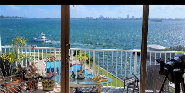 balcony with a pool and a water view