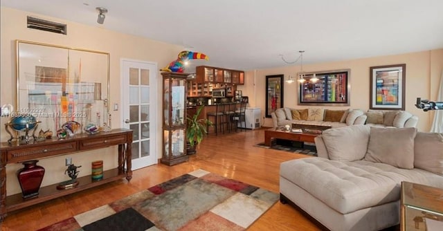 living room with light wood-type flooring and an inviting chandelier