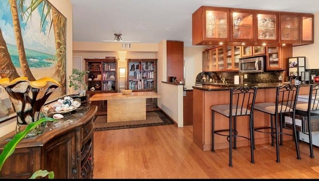 bar featuring light hardwood / wood-style flooring and tasteful backsplash