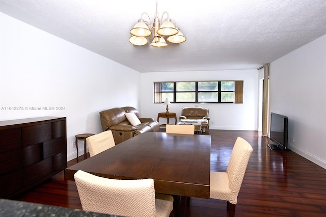 dining space with dark wood-type flooring, a textured ceiling, and an inviting chandelier