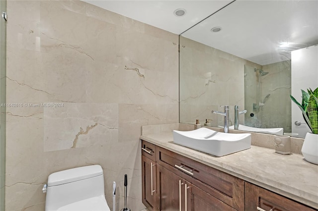 bathroom with vanity, a shower, toilet, and tile walls