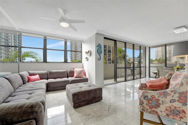 living room featuring a wealth of natural light, ceiling fan, and expansive windows