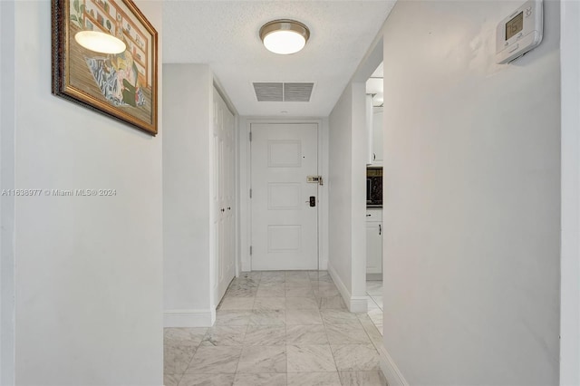 hallway with a textured ceiling