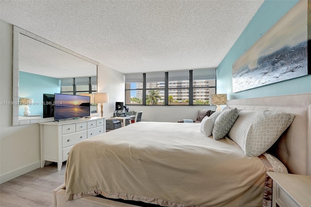 bedroom featuring a textured ceiling and light hardwood / wood-style flooring