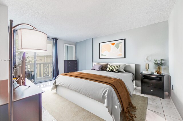 bedroom with access to outside, light tile patterned flooring, and a textured ceiling