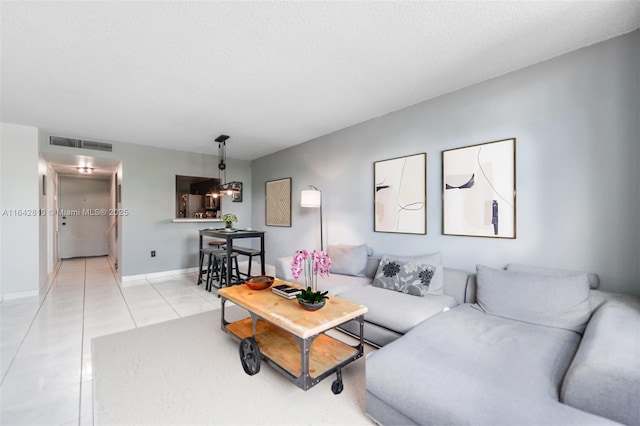 tiled living room featuring a textured ceiling