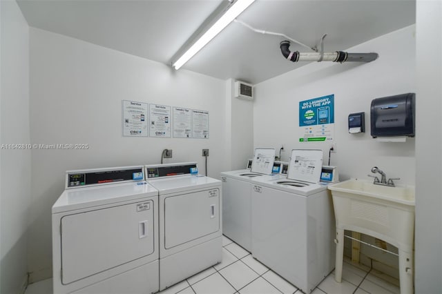 laundry area with washing machine and clothes dryer, sink, and light tile patterned flooring