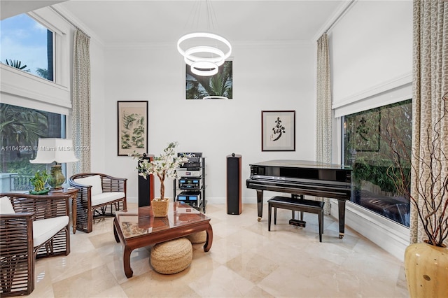 sitting room with crown molding and an inviting chandelier