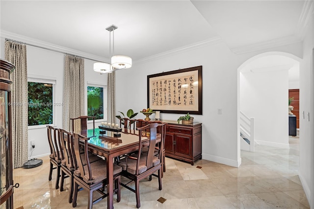 dining area featuring ornamental molding, arched walkways, and baseboards