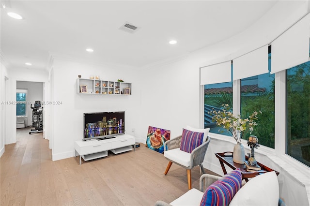 sitting room with light wood-style floors, baseboards, ornamental molding, and recessed lighting