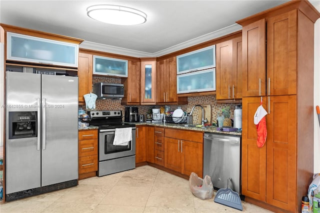 kitchen featuring sink, decorative backsplash, appliances with stainless steel finishes, and dark stone counters