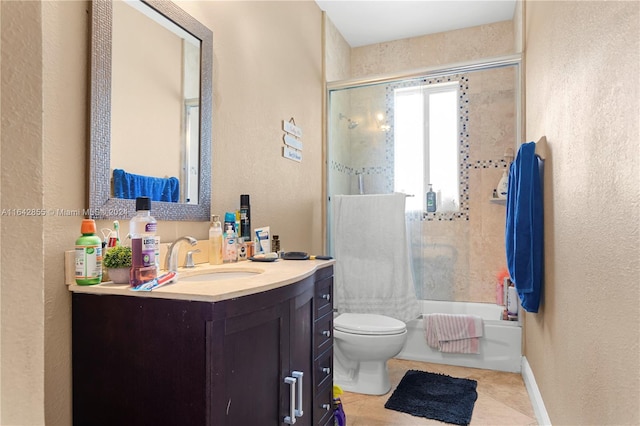 full bathroom with tile patterned floors, vanity, bath / shower combo with glass door, and toilet