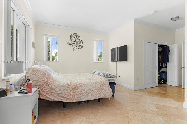 tiled bedroom featuring a closet and crown molding