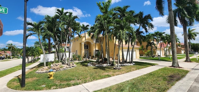 mediterranean / spanish-style home featuring a garage and a front yard