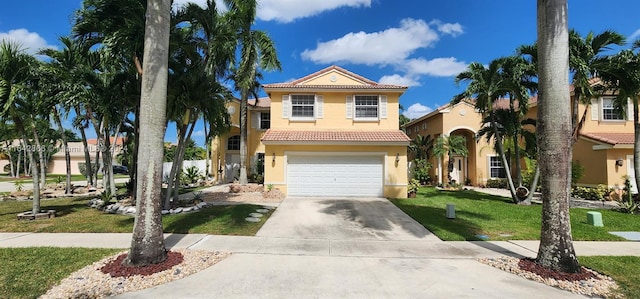 mediterranean / spanish house featuring a garage and a front yard