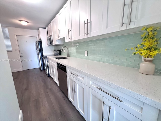 kitchen with decorative backsplash, dark hardwood / wood-style flooring, white cabinetry, sink, and stainless steel appliances