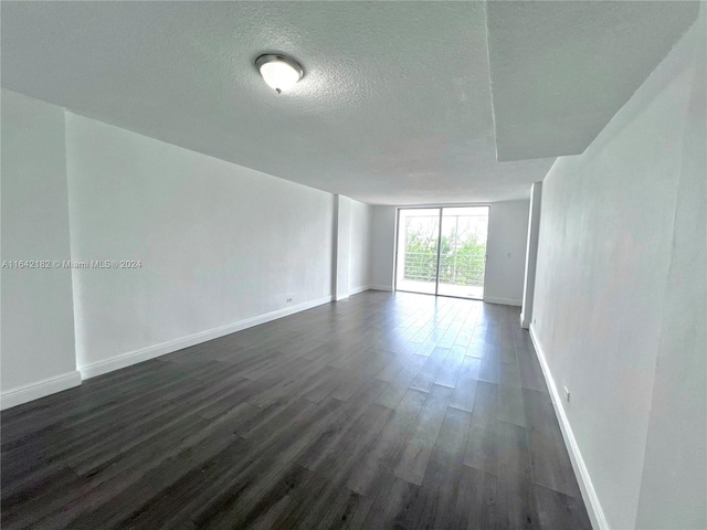 unfurnished room featuring dark hardwood / wood-style floors and a textured ceiling