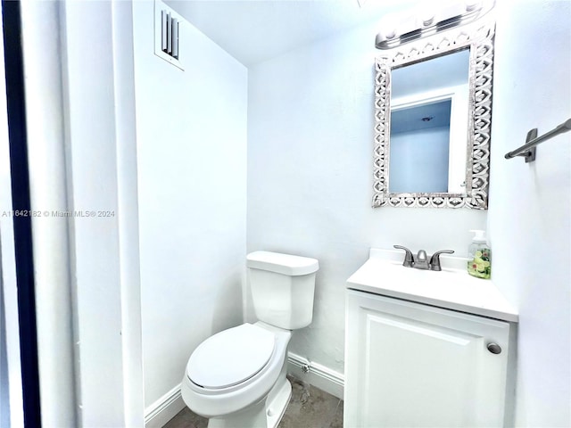 bathroom with tile patterned flooring, vanity, and toilet