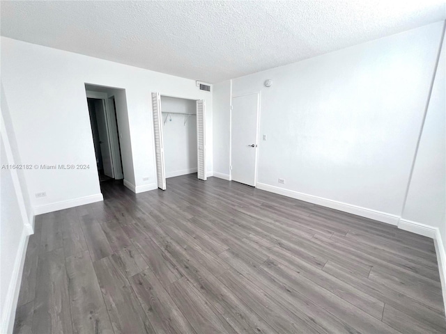 unfurnished bedroom with a textured ceiling and wood-type flooring