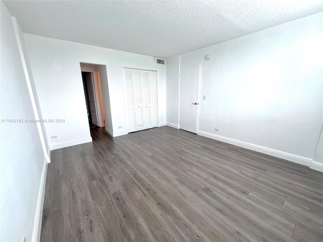 unfurnished bedroom with a closet, a textured ceiling, and wood-type flooring