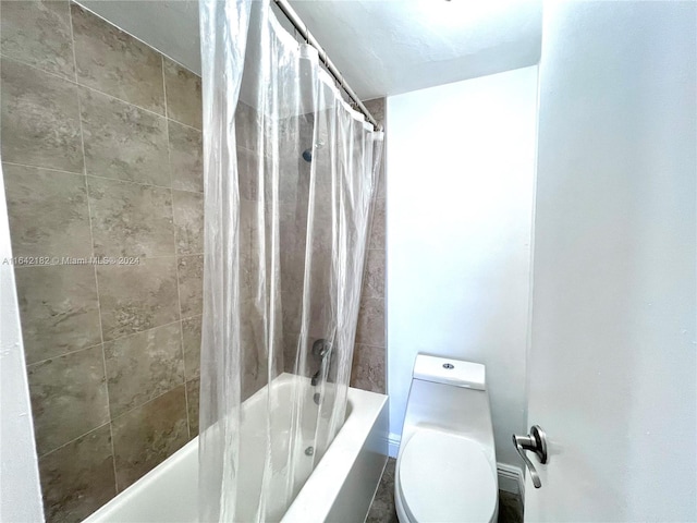 bathroom featuring shower / bath combination with curtain and toilet