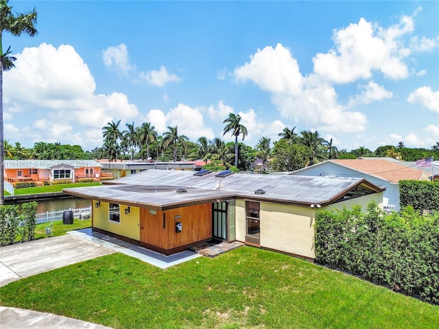 rear view of property with a lawn