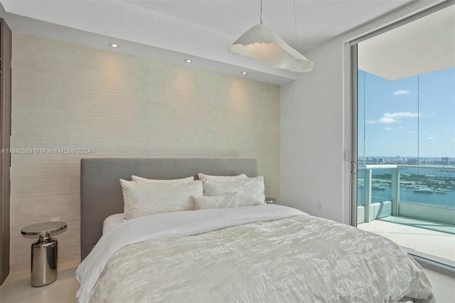 bedroom featuring floor to ceiling windows, a water view, and access to exterior