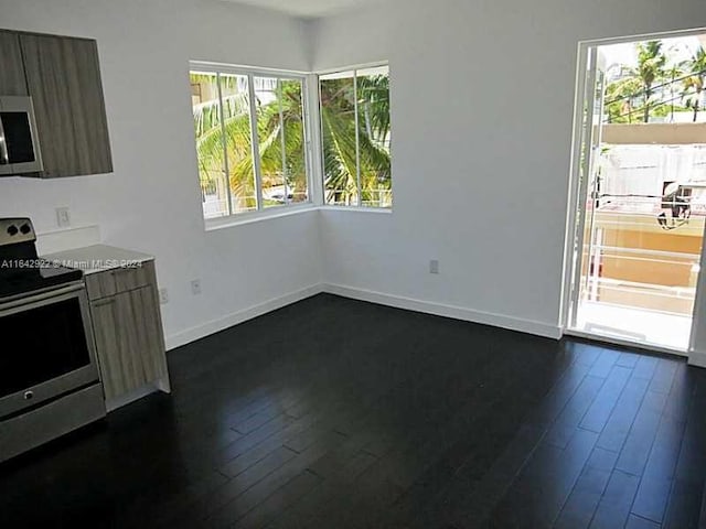 unfurnished dining area with dark wood-type flooring