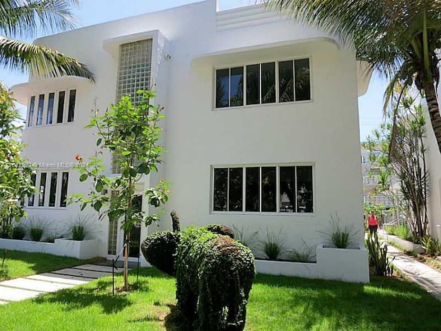 art deco house featuring a front lawn