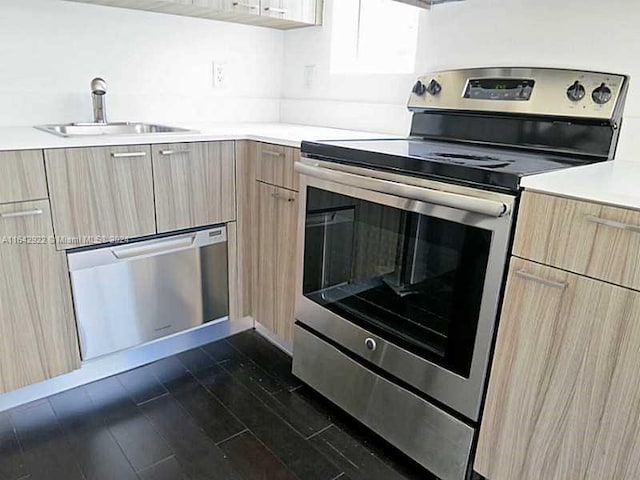 kitchen featuring sink, stainless steel appliances, dark wood-type flooring, and light brown cabinetry