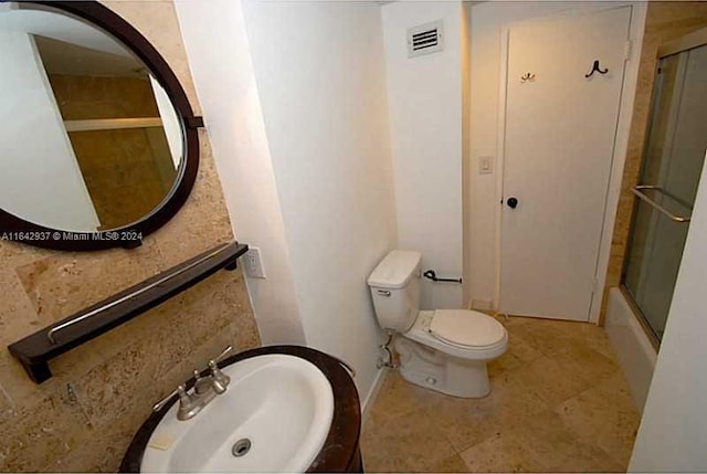 bathroom featuring sink, toilet, and tile patterned flooring