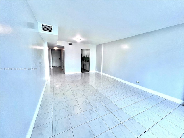 empty room featuring marble finish floor, baseboards, and visible vents