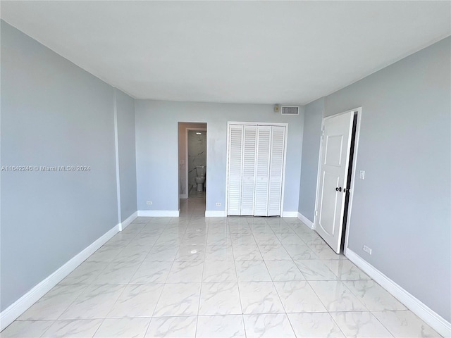 unfurnished bedroom featuring light tile patterned floors and a closet