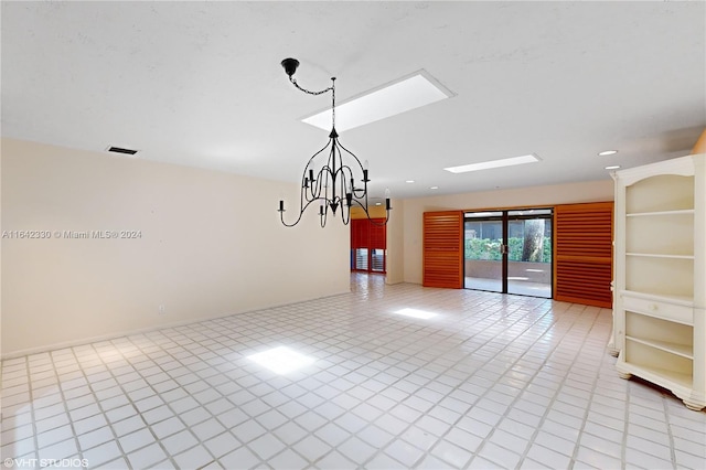 unfurnished room featuring a skylight, visible vents, and an inviting chandelier