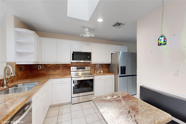 kitchen featuring open shelves, visible vents, decorative backsplash, appliances with stainless steel finishes, and a sink