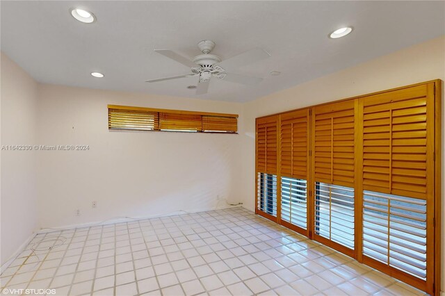 unfurnished bedroom featuring ceiling fan, light tile patterned floors, and a closet